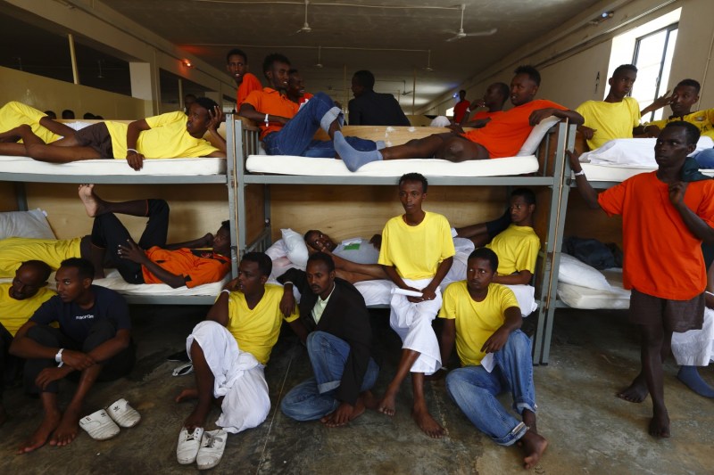 Immigrants sit in their dormitory at the Safi barracks detention centre for immigrants that currently holds around 600 detainees in Safi, outside Valletta, July 19, 2013. Migrants who land in Malta face mandatory detention that can last for 18 months but figures show nearly half are allowed out sooner, following the granting of refugee status or humanitarian protection, according to official sources.  Malta will be given concrete assistance by the European Commission to return failed asylum seekers to their country of origin, the government has announced. 