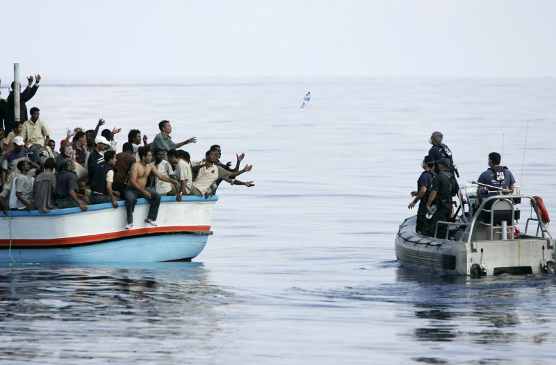 Armed Forces of Malta marines toss bottles of water to a group of around 180 people as a rescue operation gets underway after their vessel ran into engine trouble, some 30km (19 miles) southwest of Malta September 25, 2005. 