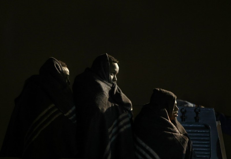 Migrants wait to disembark from an Armed Forces of Malta (AFM) vessel at the AFM Maritime Squadron base at Haywharf in Valletta's Marsamxett Harbour, late March 20, 2014. 90 migrants claiming to be from Somalia were rescued by the AFM some 25 nautical miles off the Maltese islands when their boat ran into difficulties, according to army sources.