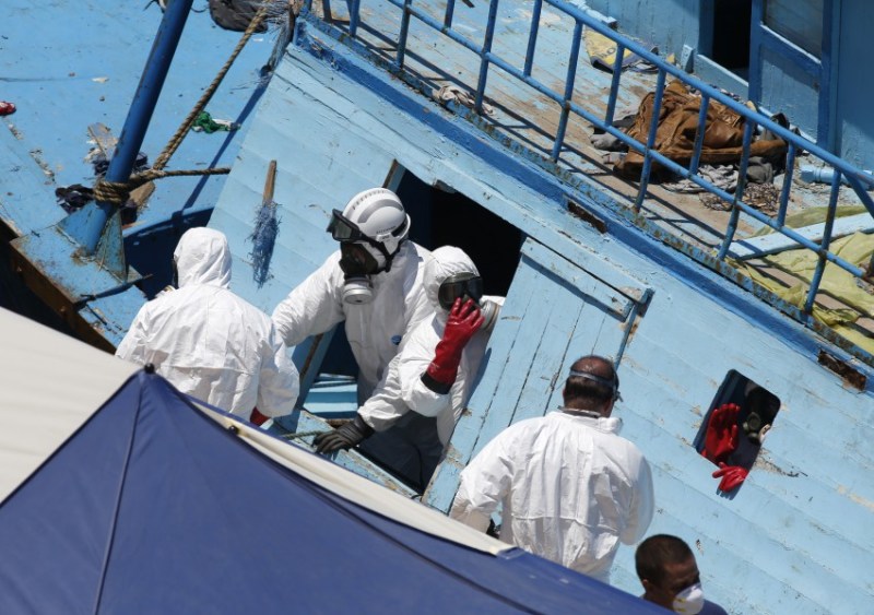 Hazmat and forensic officers work on board a fishing boat, on which 19 migrants are reported to have died, at the Armed Forces of Malta (AFM) Maritime Squadron base in Valletta's Marsamxett Harbour, after it was towed to Malta by the AFM, July 20, 2014. Nineteen people died trying to reach Italy on a boat packed with hundreds of migrants, probably poisoned by carbon monoxide fumes from its engines, said the Italian Navy on Saturday, which has rescued more than 4,000 migrants in the last three days. 