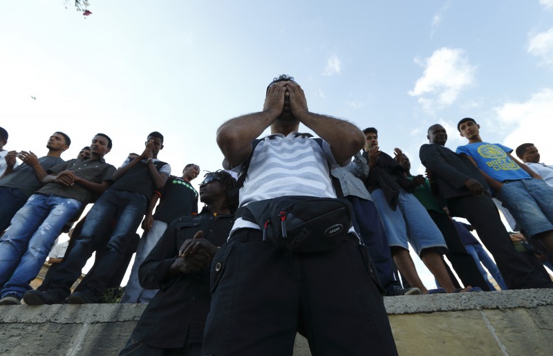 Syrian and Sub-Saharan African migrants attend a commemorative service organised by the Jesuit Refugee Services for immigrants who lost their lives at sea earlier this month, in Valletta's Grand Harbour, October 25, 2013.  