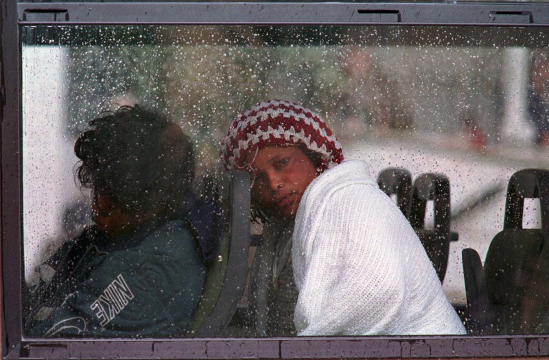 A refugee from Sierra Leone, exhausted and lucky to be alive, slumps her head against the head rest on a Maltese Army coach near the Russian survey ship "Akademia Nikolas Strakov" in Grand Harbour in Valletta on December 6, 1998. The group of 52 refugees was rescued by the ship's crew 94 miles south-west of Malta. The 43 men and 9 women, from Sierra Leone, Egypt and Algeria, were found on a small open boat in rough seas. Eight of their colleagues are missing, believed drowned and a search for them was abandoned at sundown. They are believed to have been on their way to Italy.
