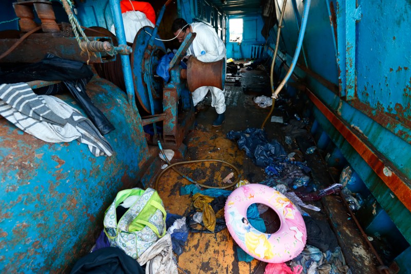 Migrants' belongings, including a child's buoyancy ring, litter the deck of a wooden boat from which migrants were rescued 10.5 miles (16 kilometres) off the coast of Libya