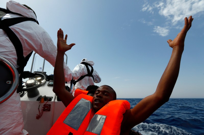 A migrant, who has just been rescued, prays on a Migrant Offshore Aid Station RHIB whilst being taken to the MOAS ship MV Phoenix some 20 miles off the coast of Libya